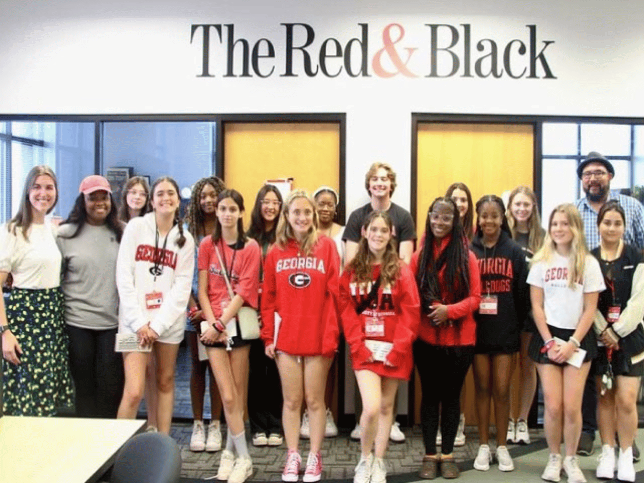 A group of students stand in front of The Red & Black at the Summer Media Academy.