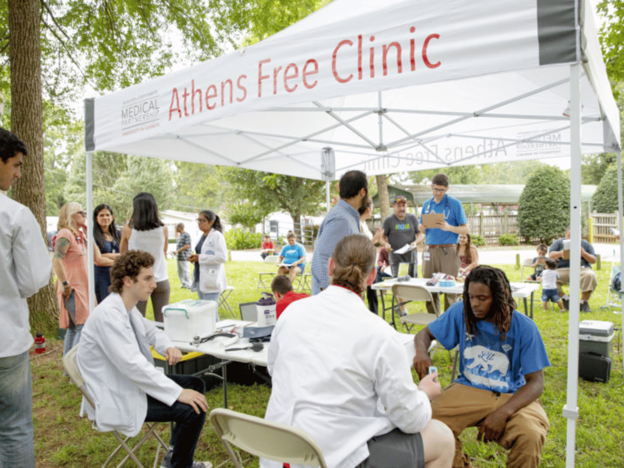 A group gathers at the Athens Free Clinic tent