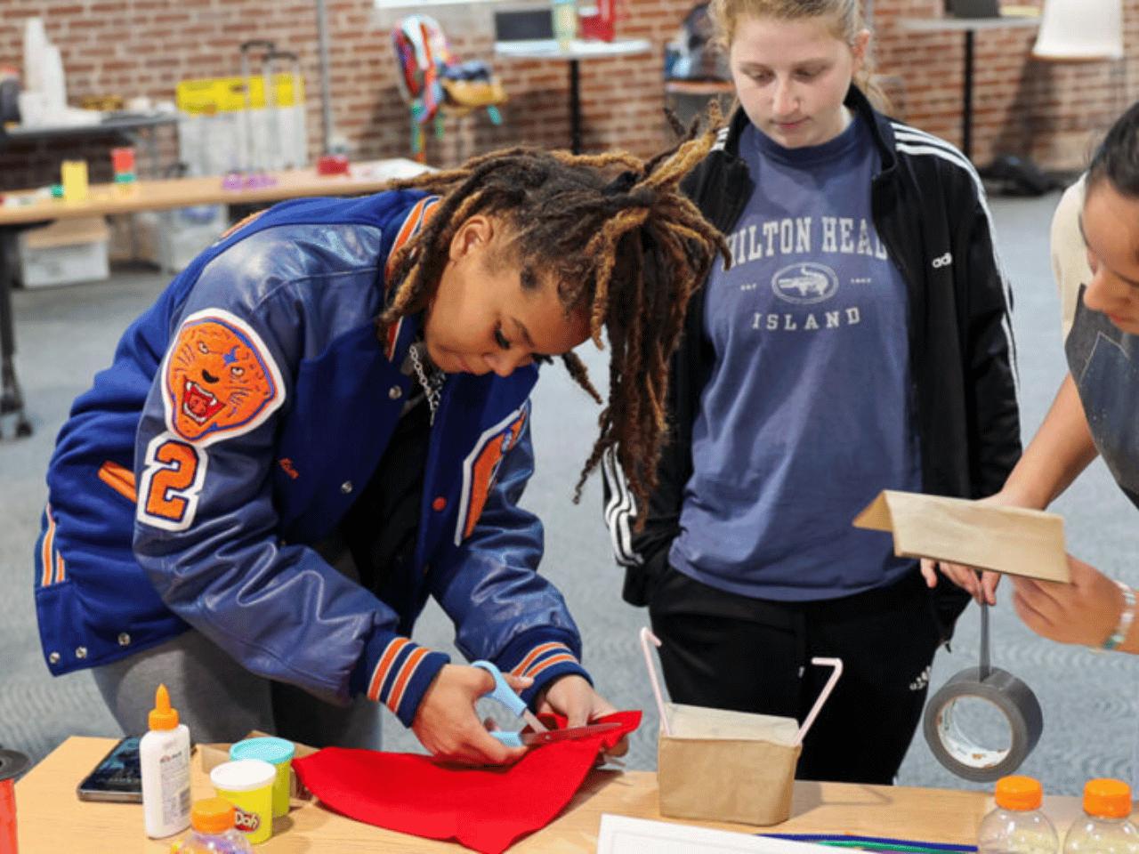 A group of Georgia Possible students work with an adult on a project.