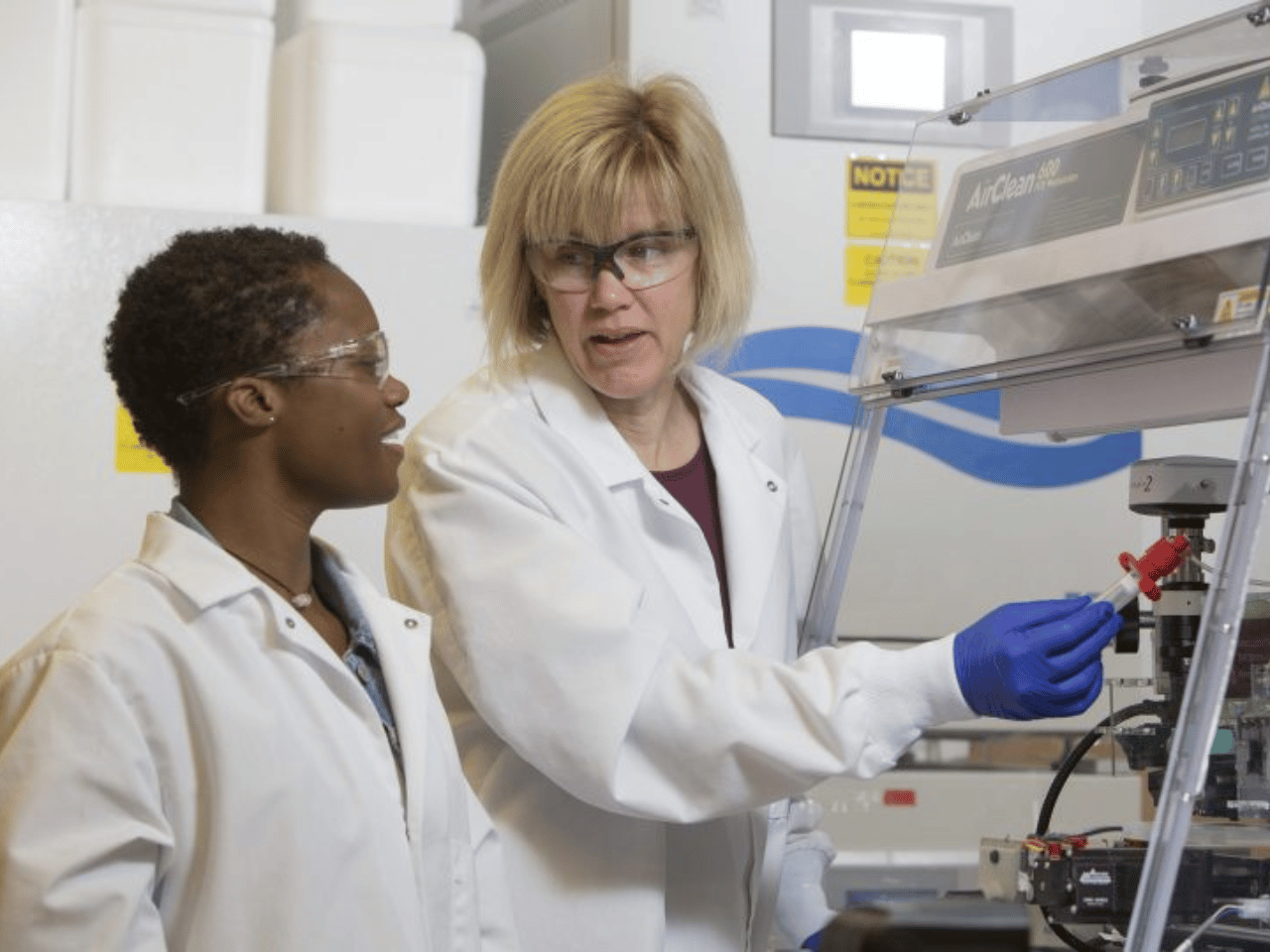 Karen Burg and another researcher work in a lab.