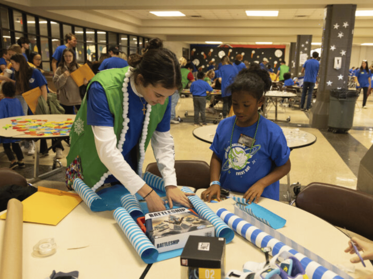 A student volunteer and Athens resident wrap gifts at the SWAB UGA event day.