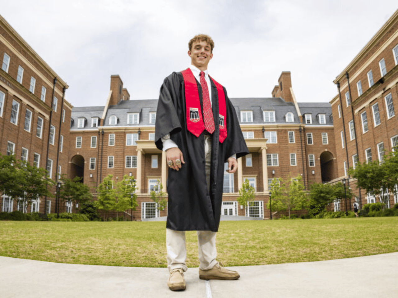 UGA graduate Trent Nesbit poses in front of the Terry College of Business.