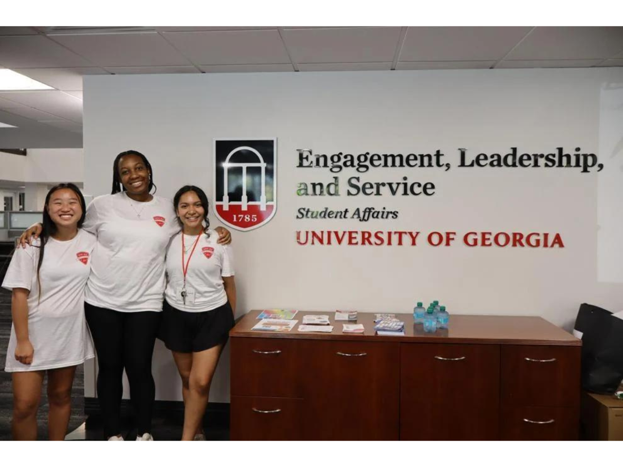 Students pose in front of the Engagement, Leadership, and Service sign at Student Affairs