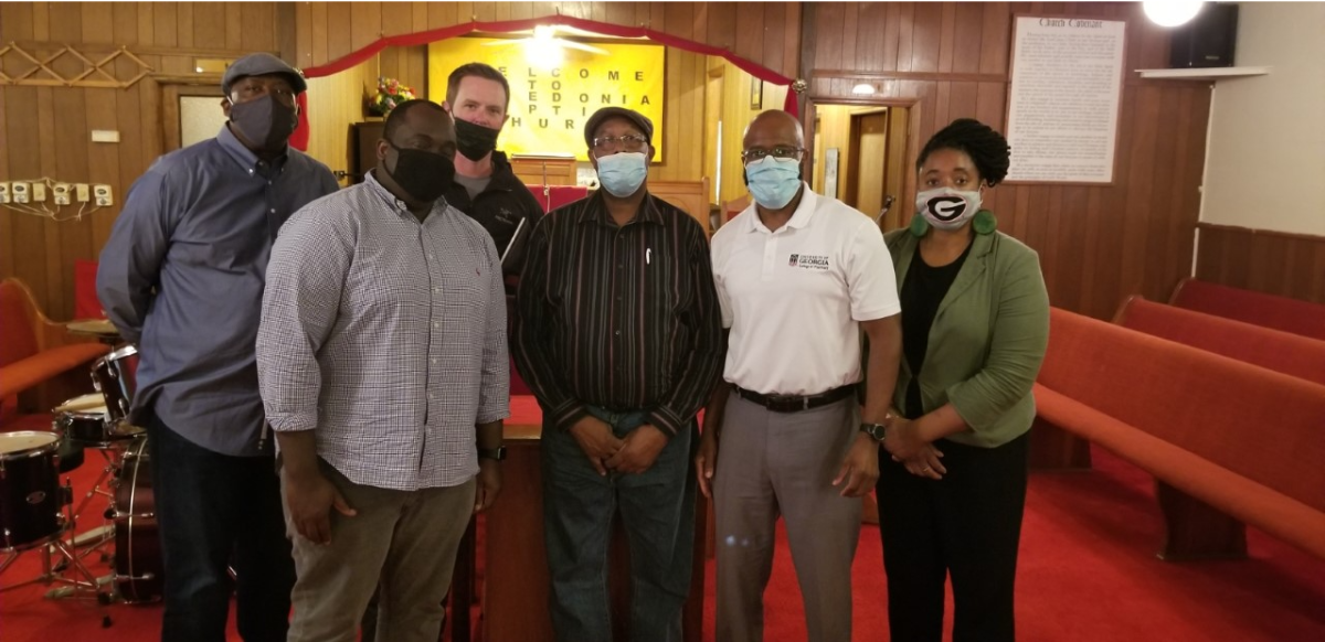 Dr. Henry N. Young conducted a site visit recently in Pulaski County to meet with Fishers of Men, a community-partner group that helps support access to health care for citizens in this rural South Georgia community. Dr. Young (white shirt) is pictured with Dr. Jeffery Lawrence, Dr. Ewan Cobran (UGA College of Pharmacy), Jason Townsend, Pastor Franklin Jordan, and Dr. Tiffany Washington (UGA School of Social Work) in the 150-year-old Macedonia Baptist Church.