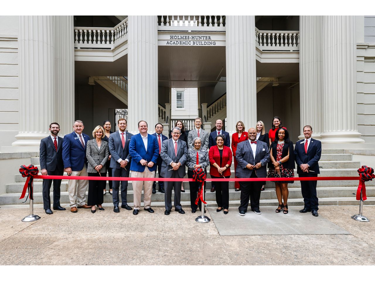 University and state leaders with the family of Hamilton Holmes behind the ribbon at the Holmes-Hunter Academic Building renovation dedication ceremony