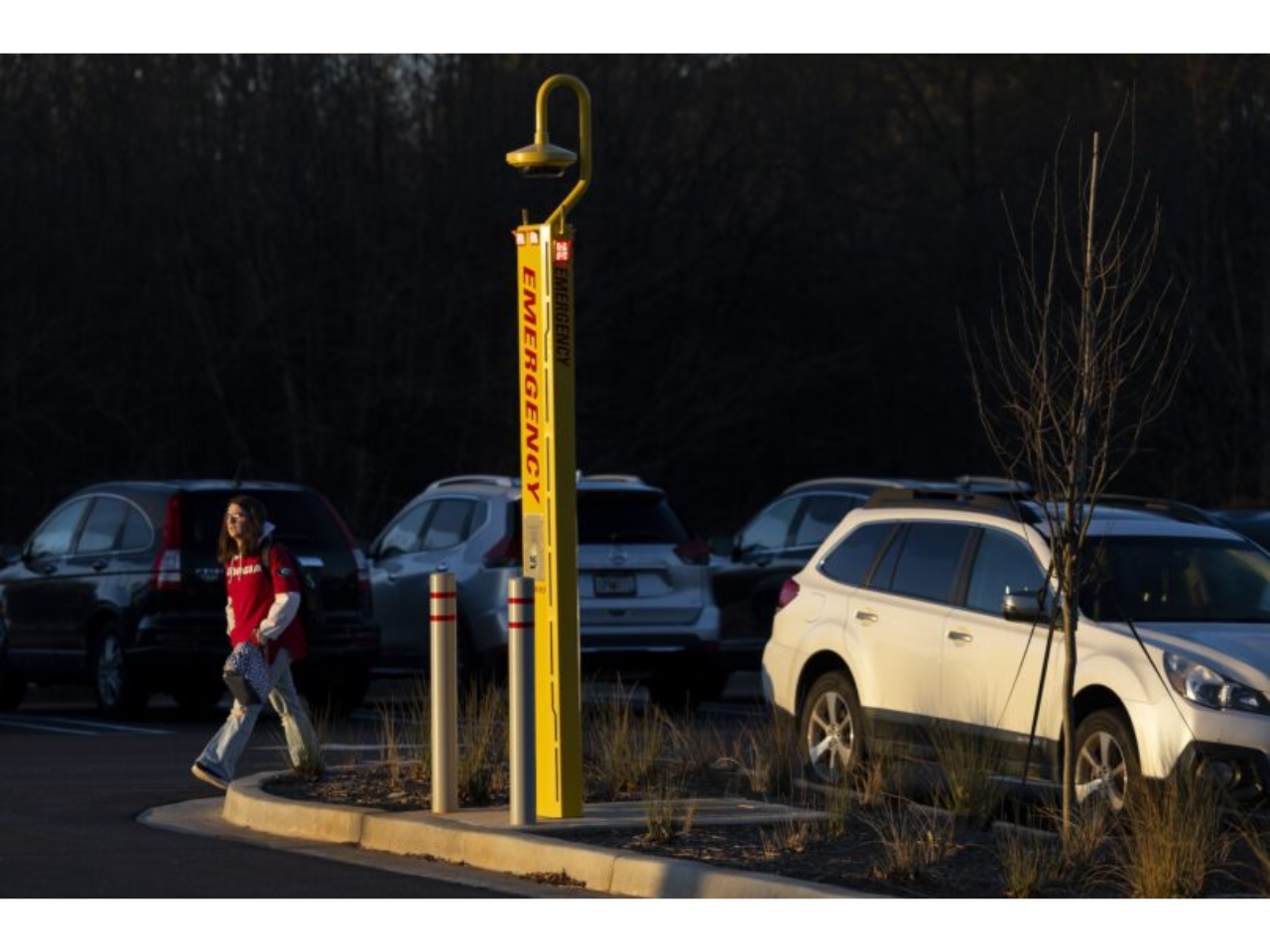 A student walks near an emergency call box installed in a parking lot near the Veterinary Medicine Teaching Hospital along College Station Road.