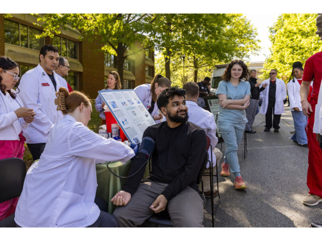 Pharmacy student Hannah Matthewson takes the blood pressure of Medical Partnership student Muhammed Mumen during the Community Health Fair at the Health Sciences Campus. (Dorothy Kozlowski/UGA)