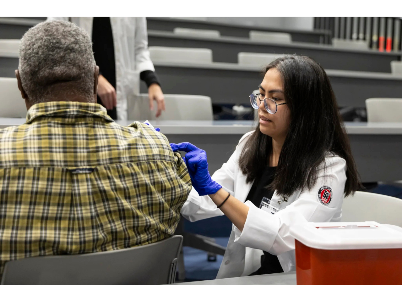 Nguyen Le administers a free flu shot to a community member during the Normaltown Community Health Fair. (Photo by Chamberlain Smith/UGA)