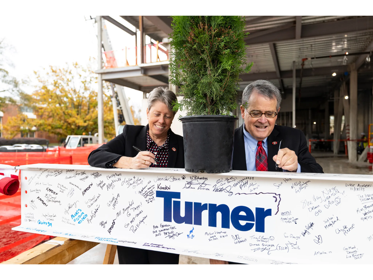 Dr. Shelley Nuss, founding dean of the UGA School of Medicine, and UGA President Jere W. Morehead sign a beam at the School of Medicine topping-out ceremony on the Health Sciences Campus. (Photo by Chamberlain Smith/UGA)
